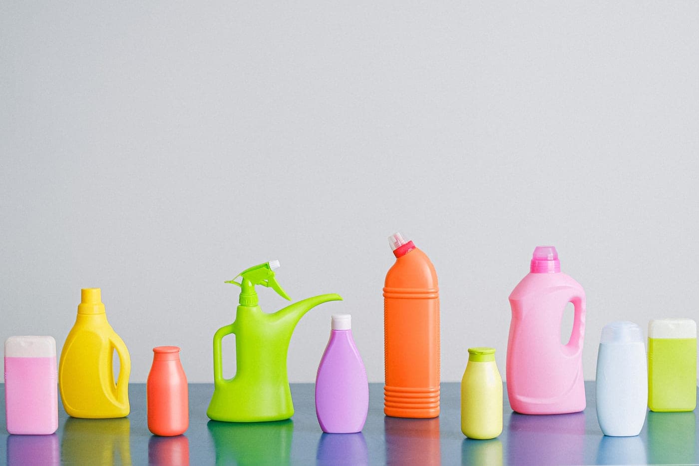 A row of cleaning product bottles lined up on a bench